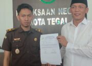 Putra Fajar Sunjaya (kanan) menyerahkan surat penarikan pemberia maaf oleh kliennyan Ponco Diyono
