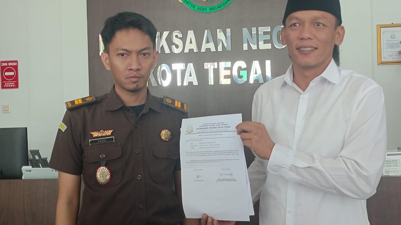 Putra Fajar Sunjaya (kanan) menyerahkan surat penarikan pemberia maaf oleh kliennyan Ponco Diyono